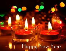 Candles lit in glass holders with a festive background, celebrating the New Year.