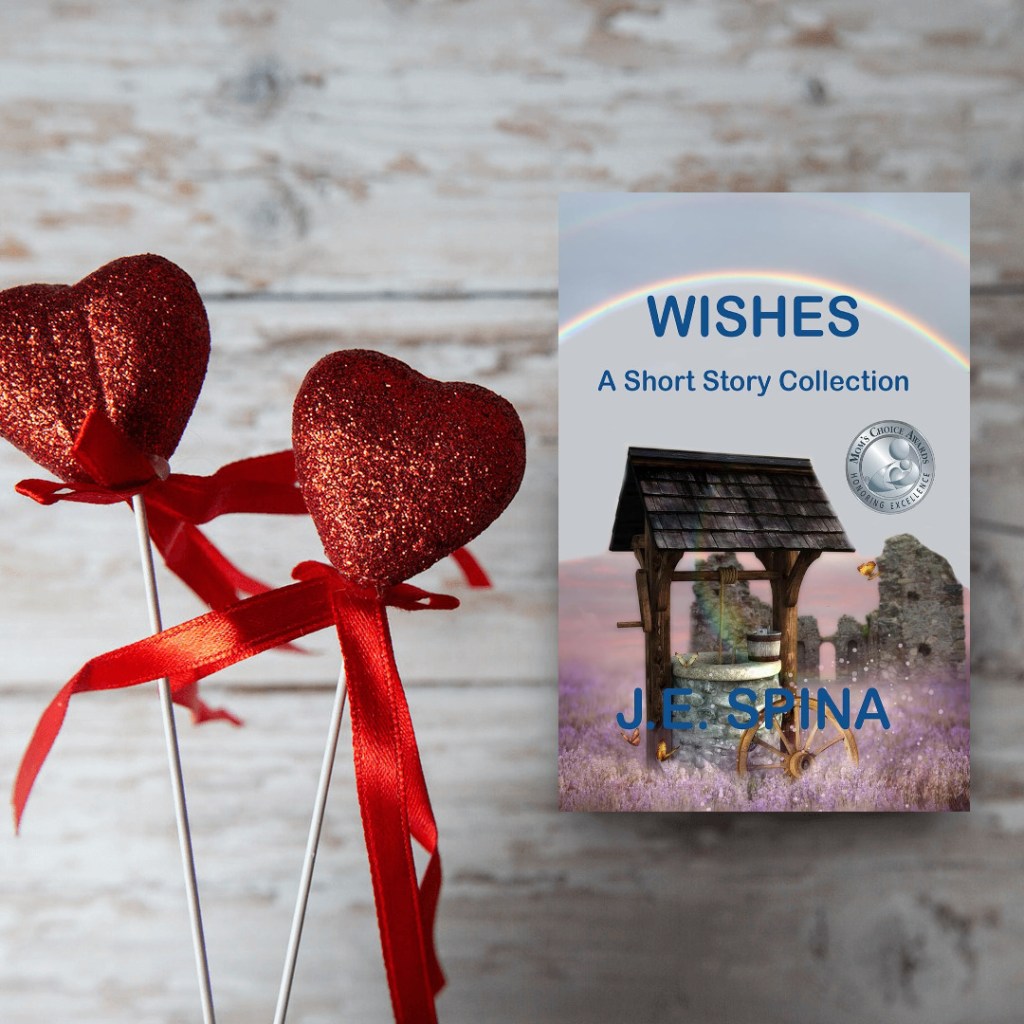 A collection of short stories titled 'WISHES' by J.E. Spina, displayed next to two glittery red heart decorations on wooden background.